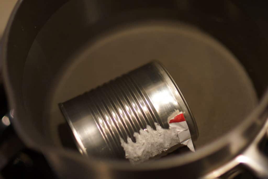 Can of sweetened condensed milk in a pot of water.