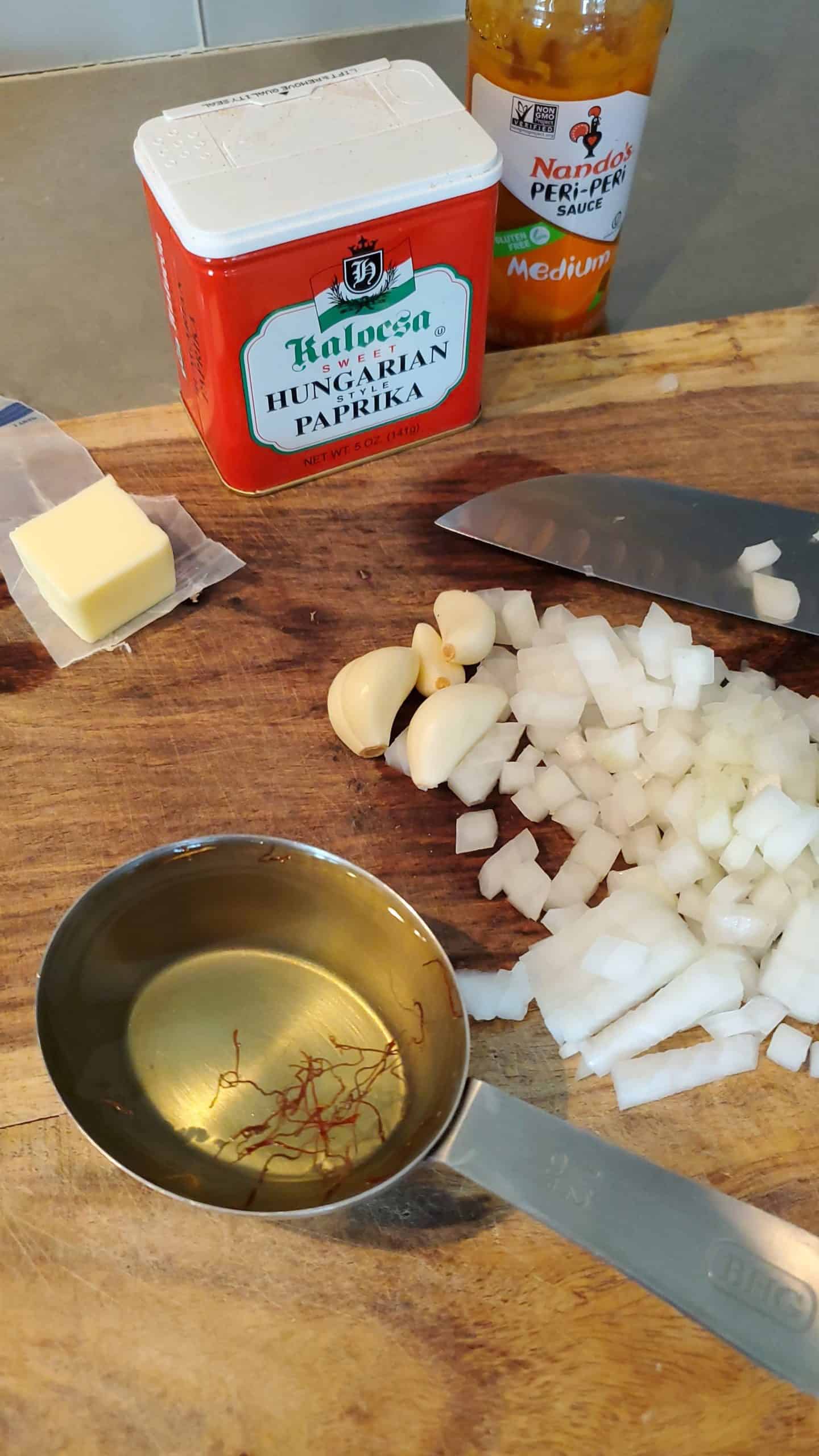Diced onion on a cutting board with white wine and paprika