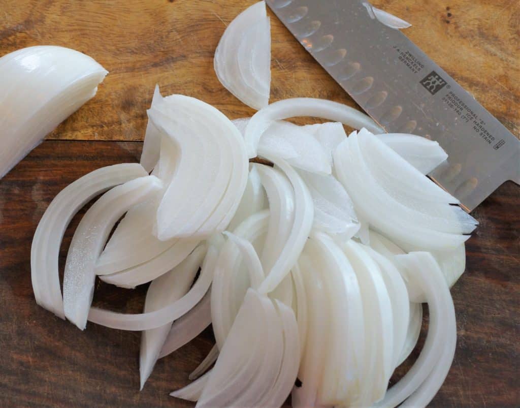 Sliced onions on a cutting board.