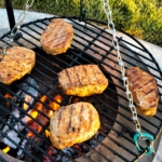 Marinated Pork chops cooking on a schwenker type grill.