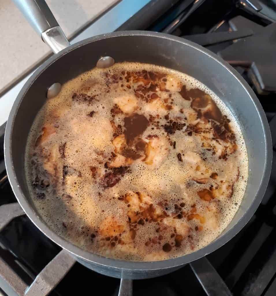 Brisket simmering in a pot with au jus.