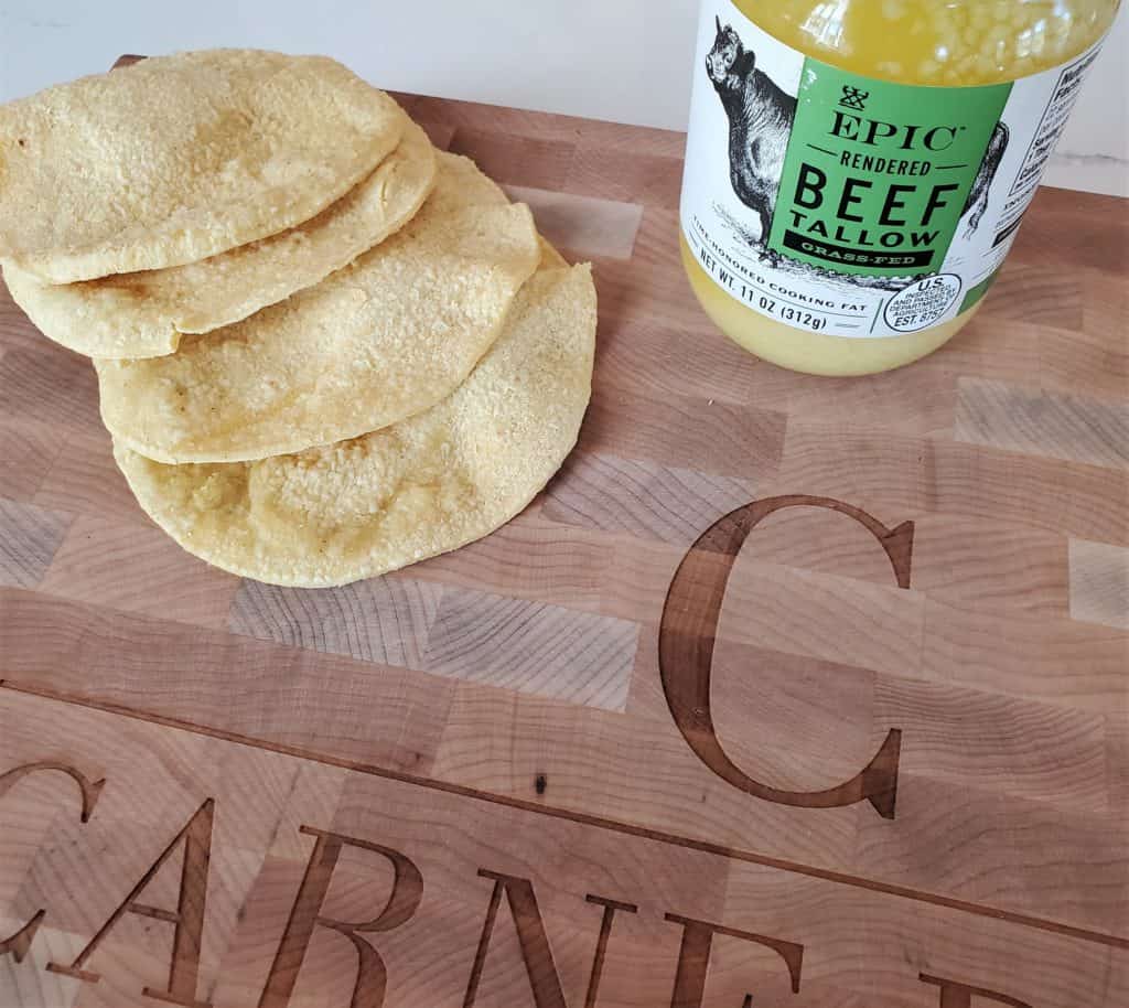 Corn tortillas and Epic Beef tallow on a cutting board.