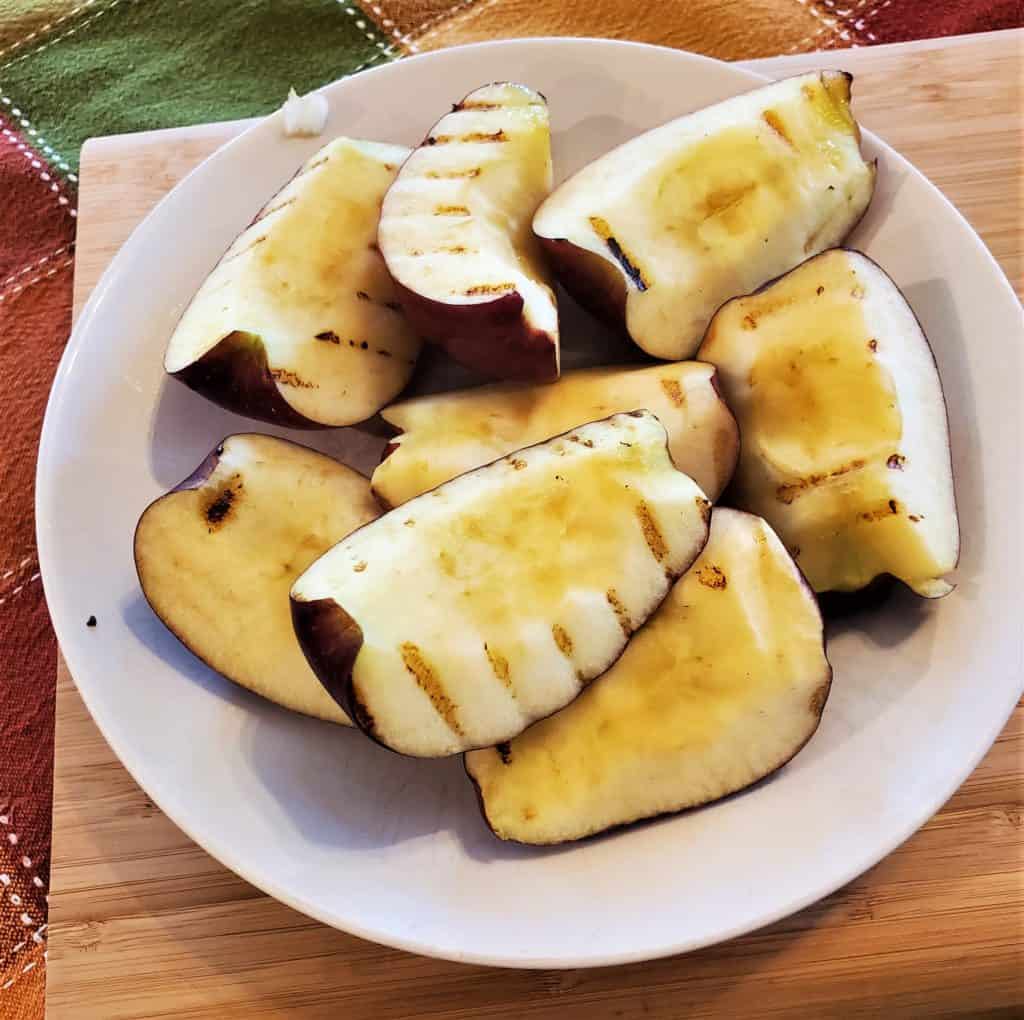 Grilled apple slices on a plate.