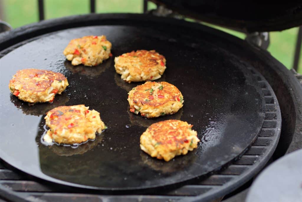 Lump crab cakes frying on a Cooking Steel on a Big Green Egg.