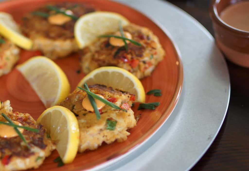 Fried Lump Crab Cakes topped with spicy aioli and chives.  Served with lemon slices and a cup of Sriracha aioli.
