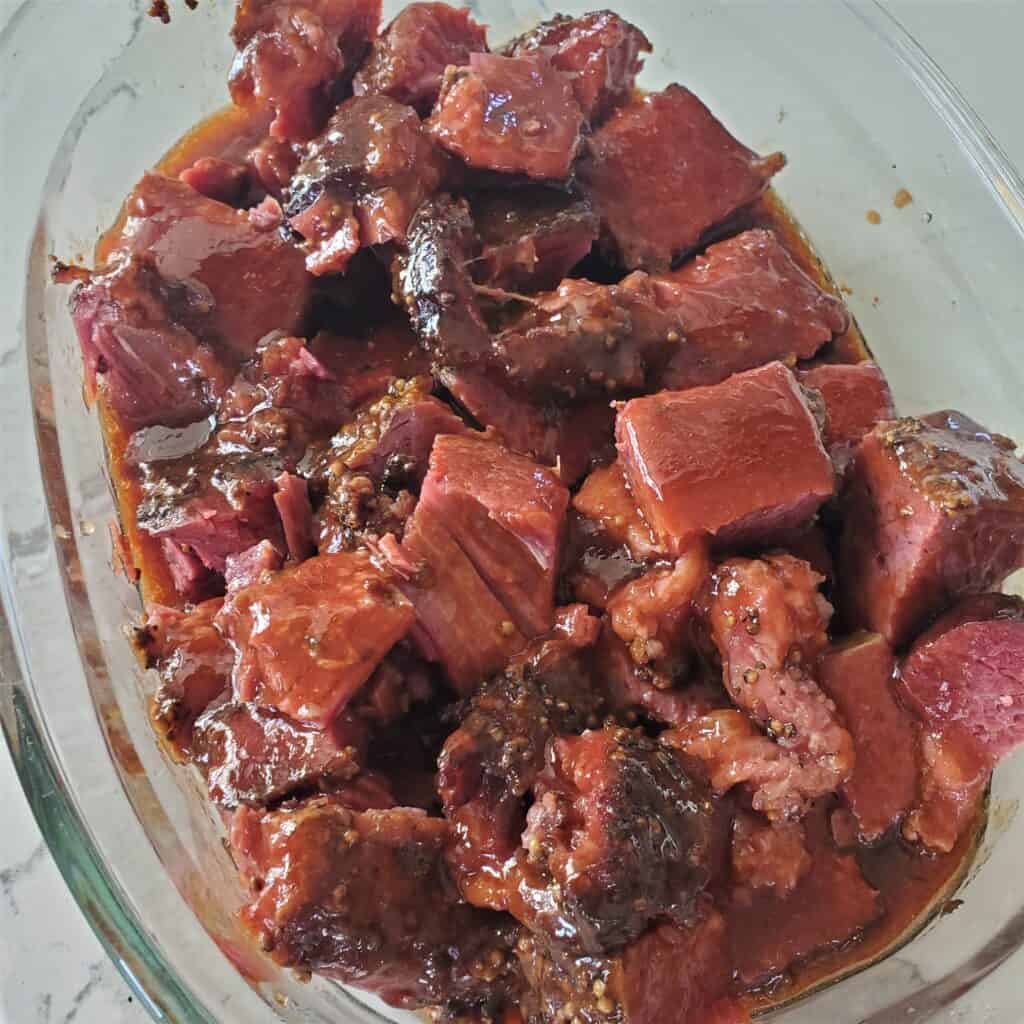 Cubed corned beef covered in BBQ sauce.