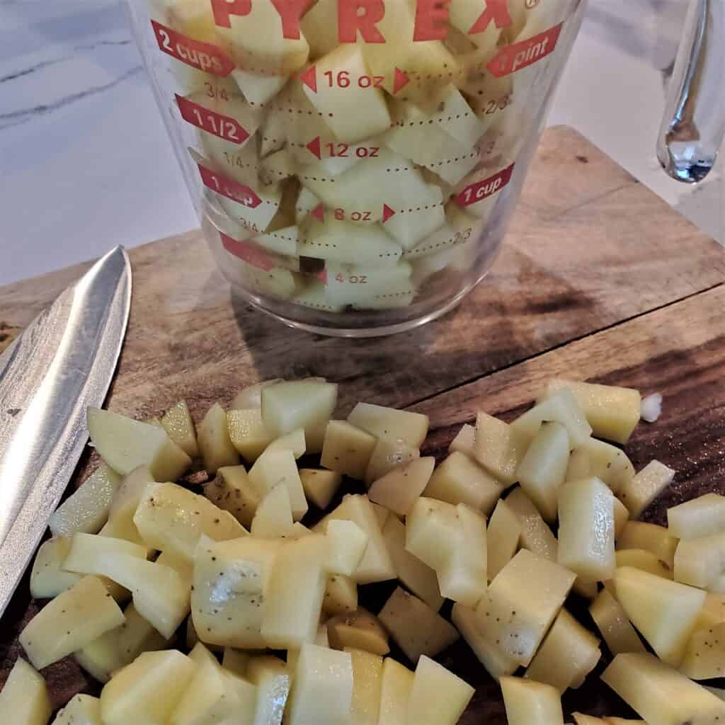 Diced potatoes in a measuring cup.