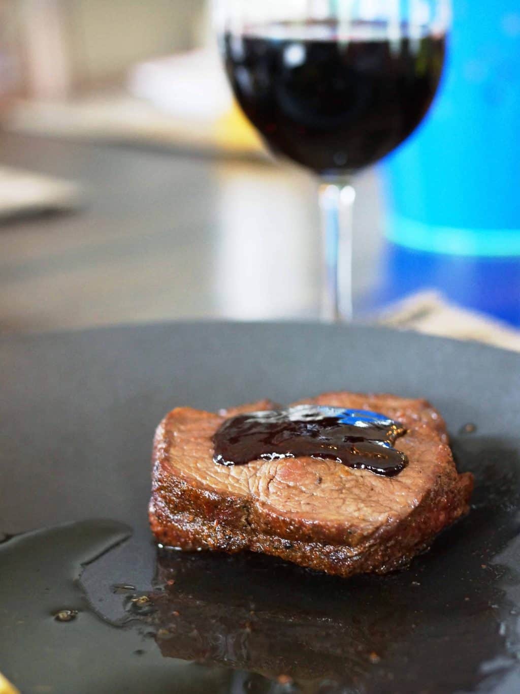 Steak with wine sauce with a glass of red wine.