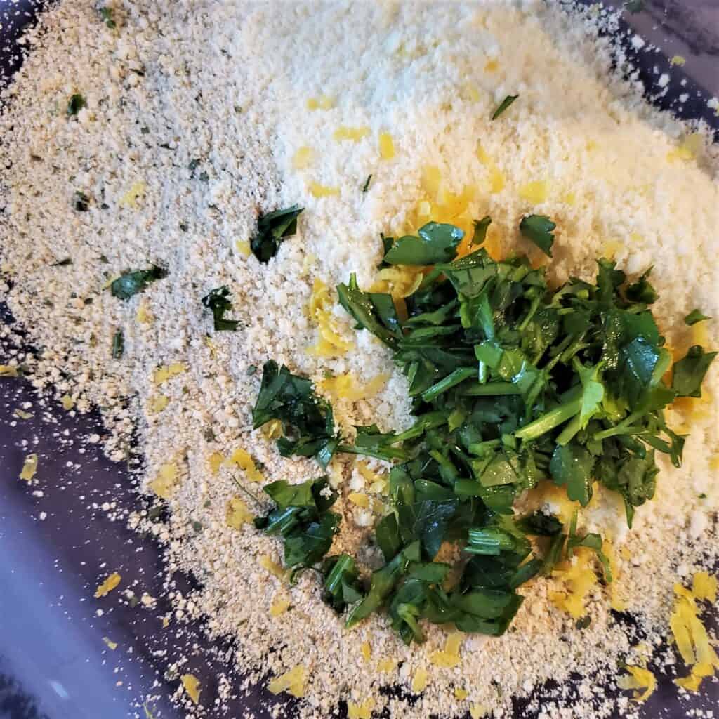 Breadcrumbs, lemon zest, and parsley being mixed for breading the chicken spiedini.