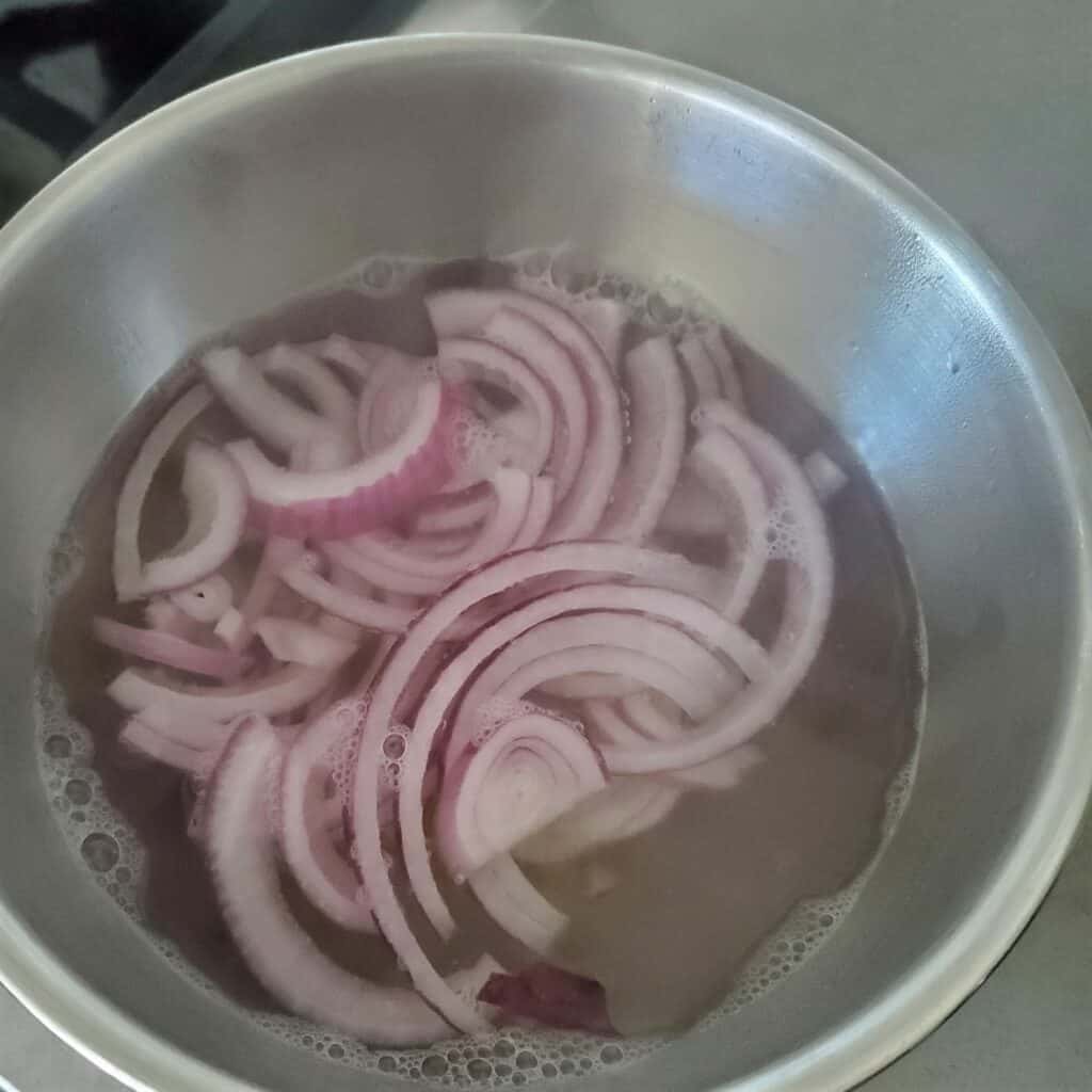 Red onions in boiling water.