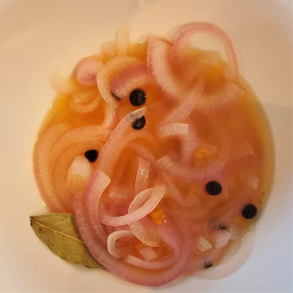 Pickling red onions in sour orange juice.