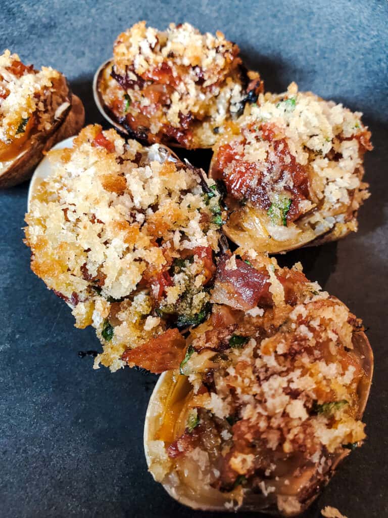 Grilled clams casino topped with panko and bacon.