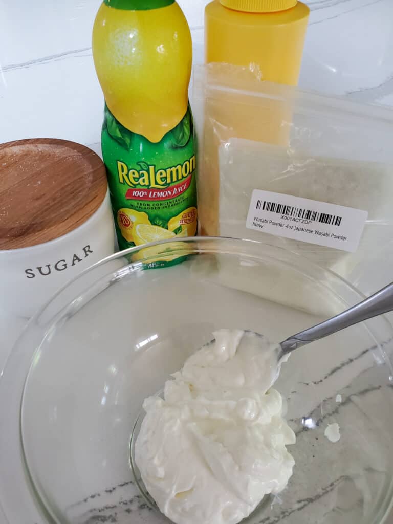 Wasabi crema with sugar, wasabi powder, and lemon juice being mixed in   bowl.