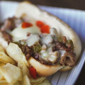 Smoked Philly Cheesesteak sandwich with potato chips.