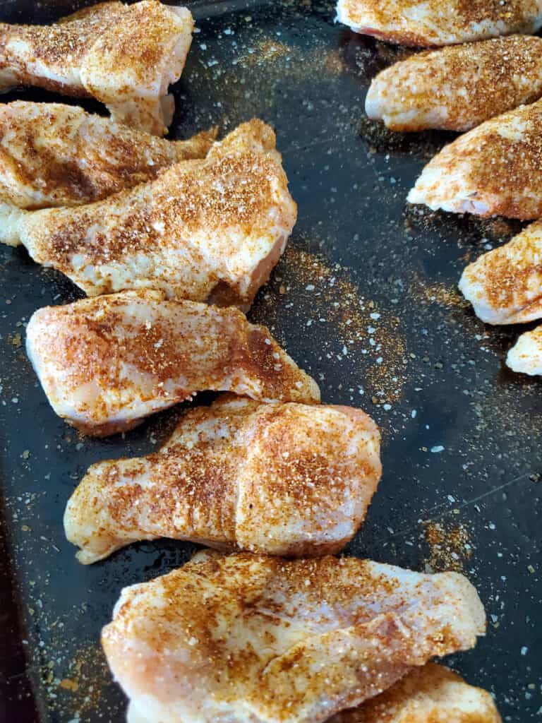 Seasoned dry rubbed party wings on a tray.