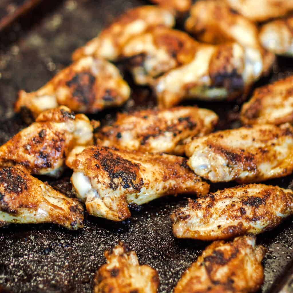 Dry rubbed chicken wings cooking on a Cooking Steel griddle