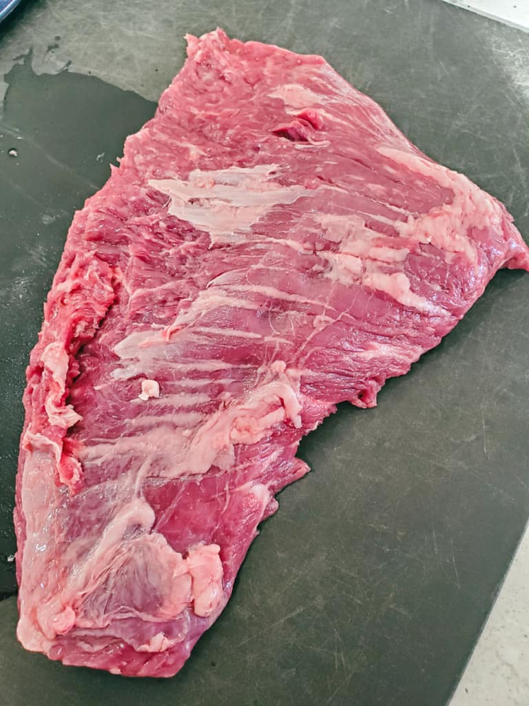 Beef flap meat on a cutting board.