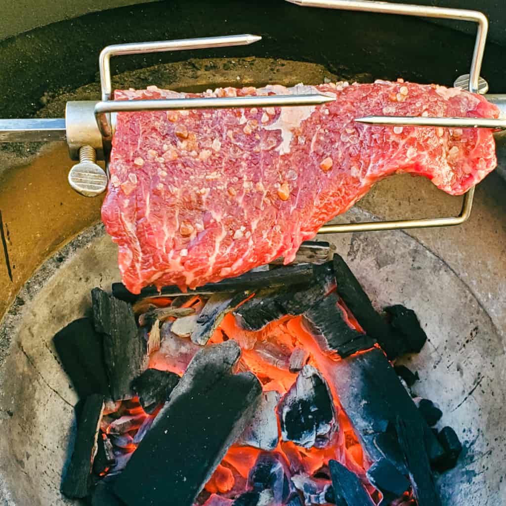 Brazilian style fraldinha on a rotisserie. grilling over an open flame.