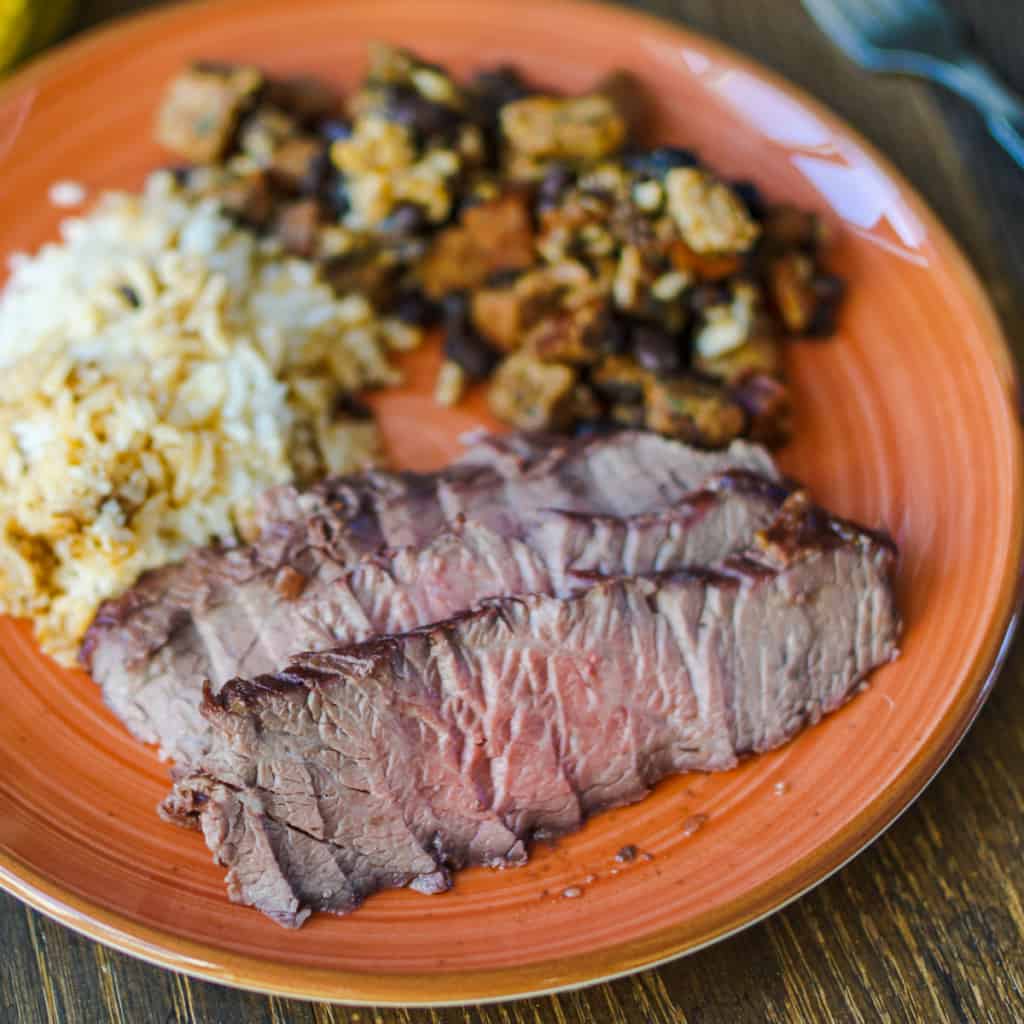 Brazilian fraldinha served with rice and feijjoada.