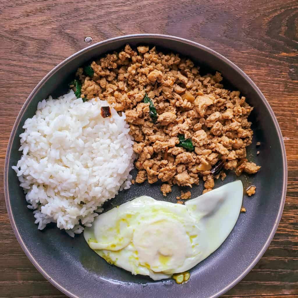 Pad Kra Pao served with white rice and a fried egg.
