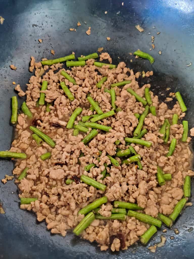 Pork Pad Kra Pao with beans cooking in a wok