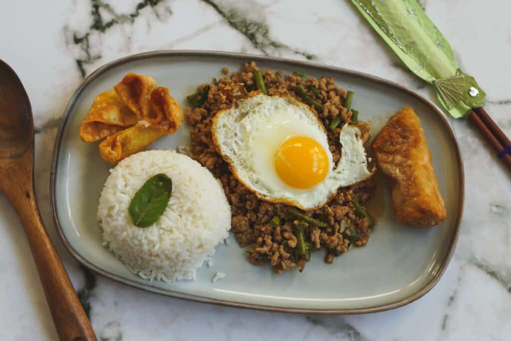Thai Holy Basil Stir Fry served with rice and a fried egg.