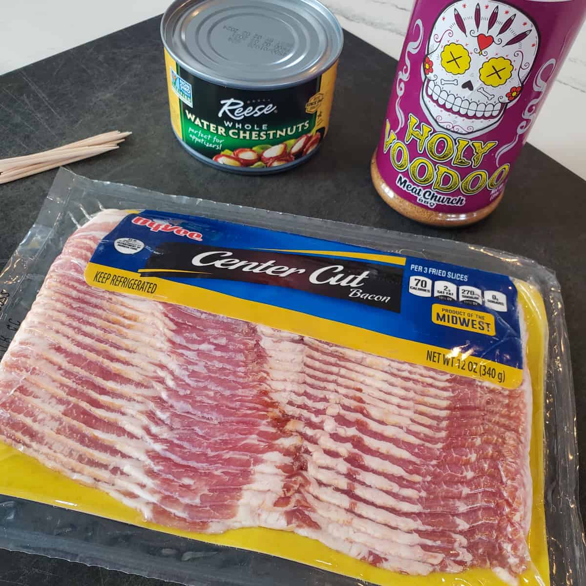 Bacon, BBQ seasoning and water chestnuts on a cutting board.