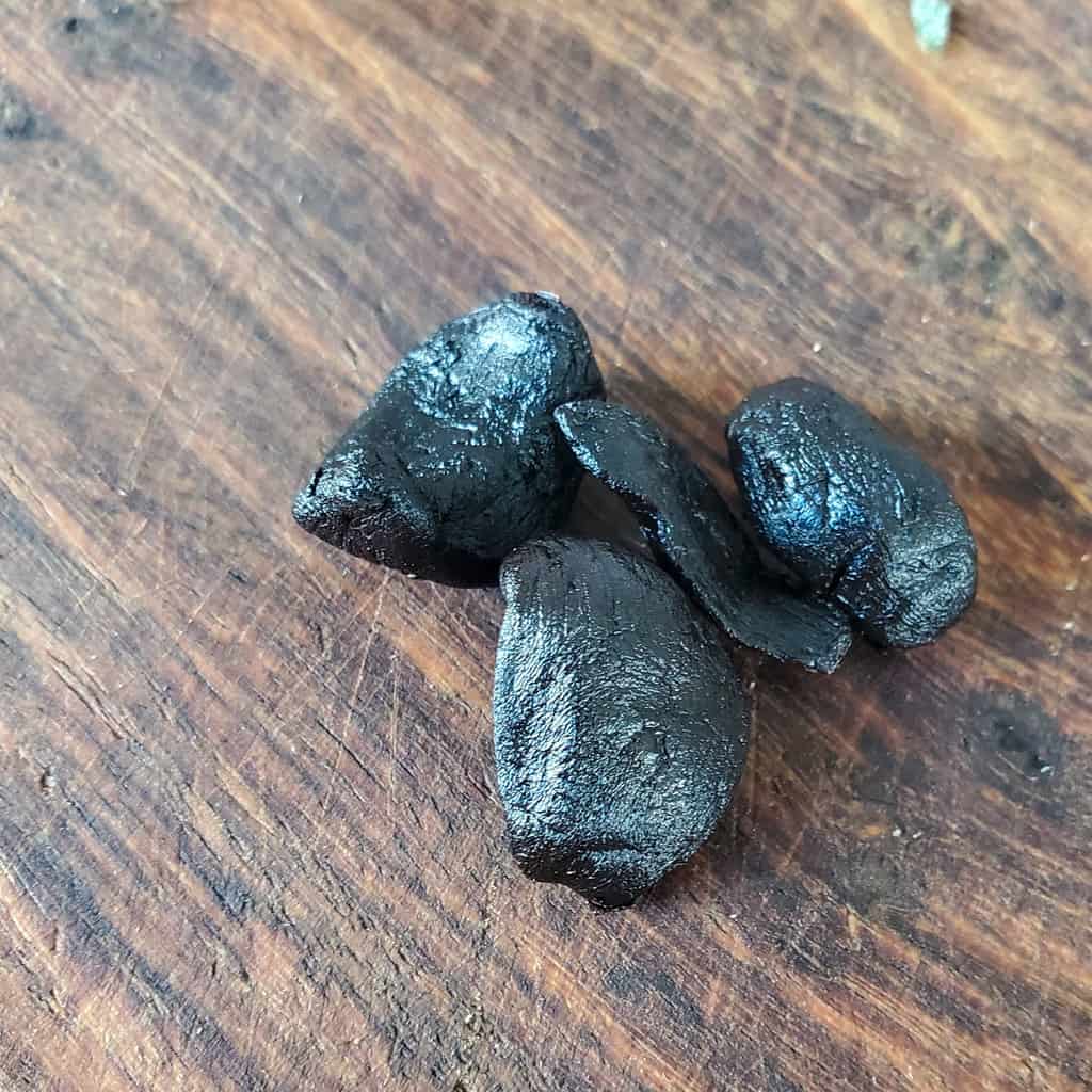 Black Garlic on a cutting board.