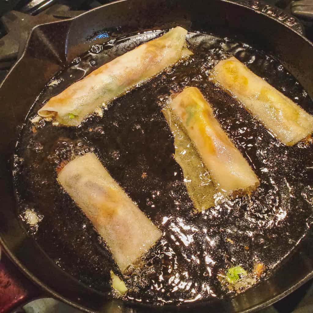 Lumpia frying in a pan.