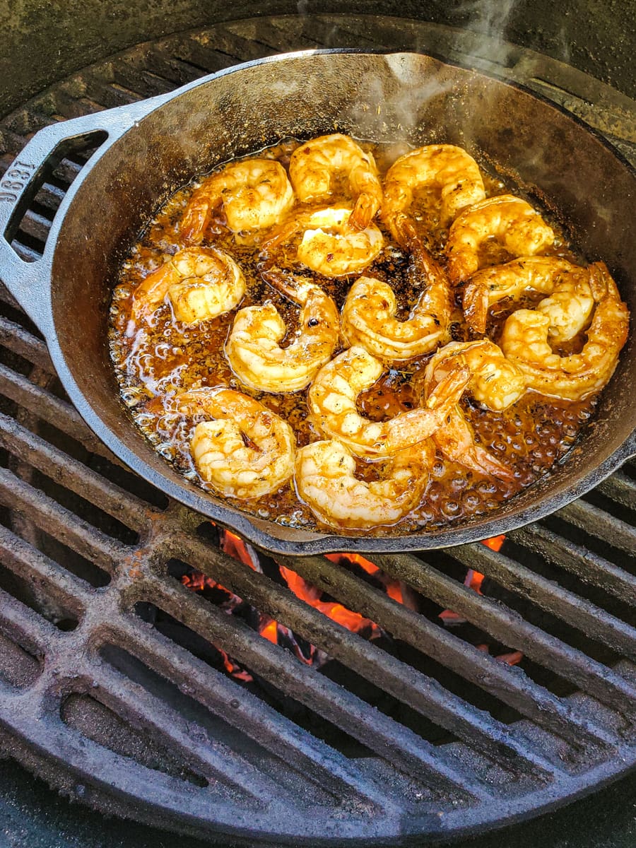 New Orleans style shrimp on a ceramic smoker in a cast iron pan.