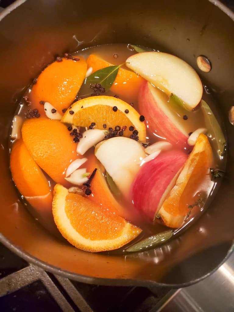Ornages and apples simmering in apple cider brine.