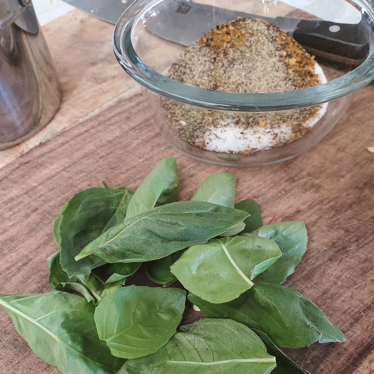 Basil, seasonings and herbs on a cutting board.