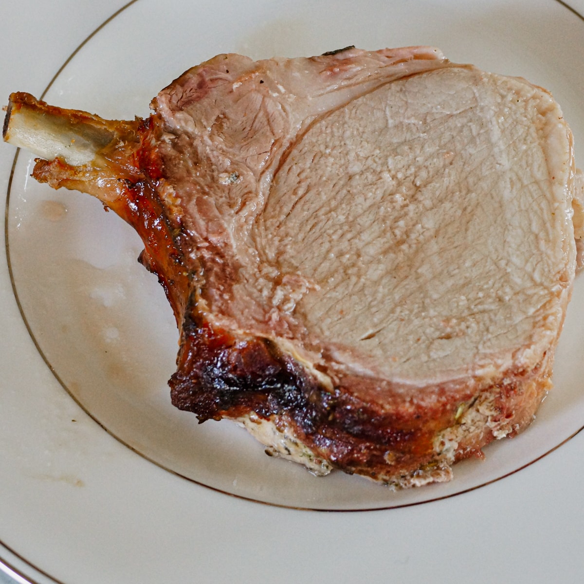 Smoked pork chop on a dinner plate.