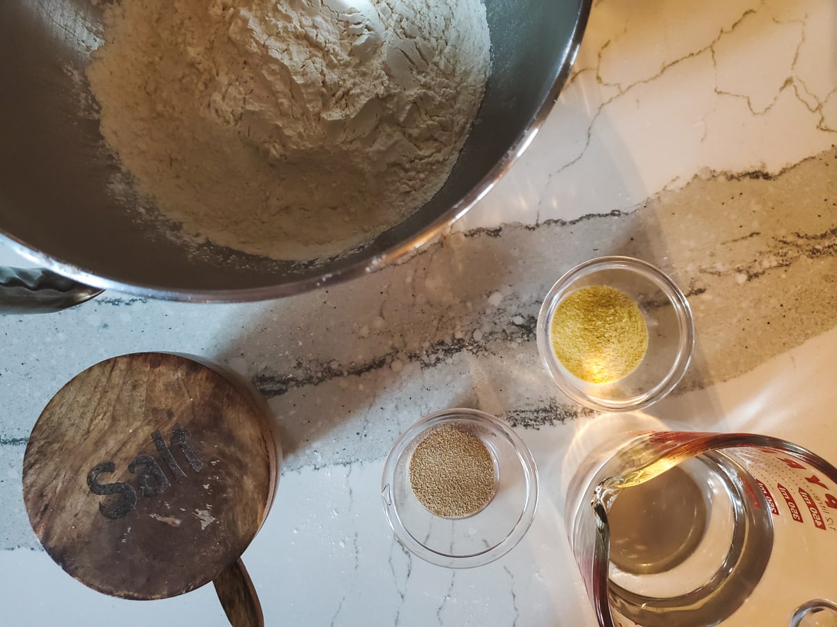 Ingredients for pizza dough on a counter.