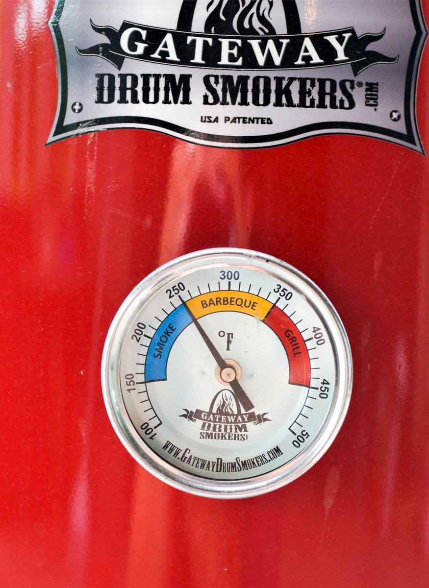 Drum smoker thermometer reading 250 degrees.