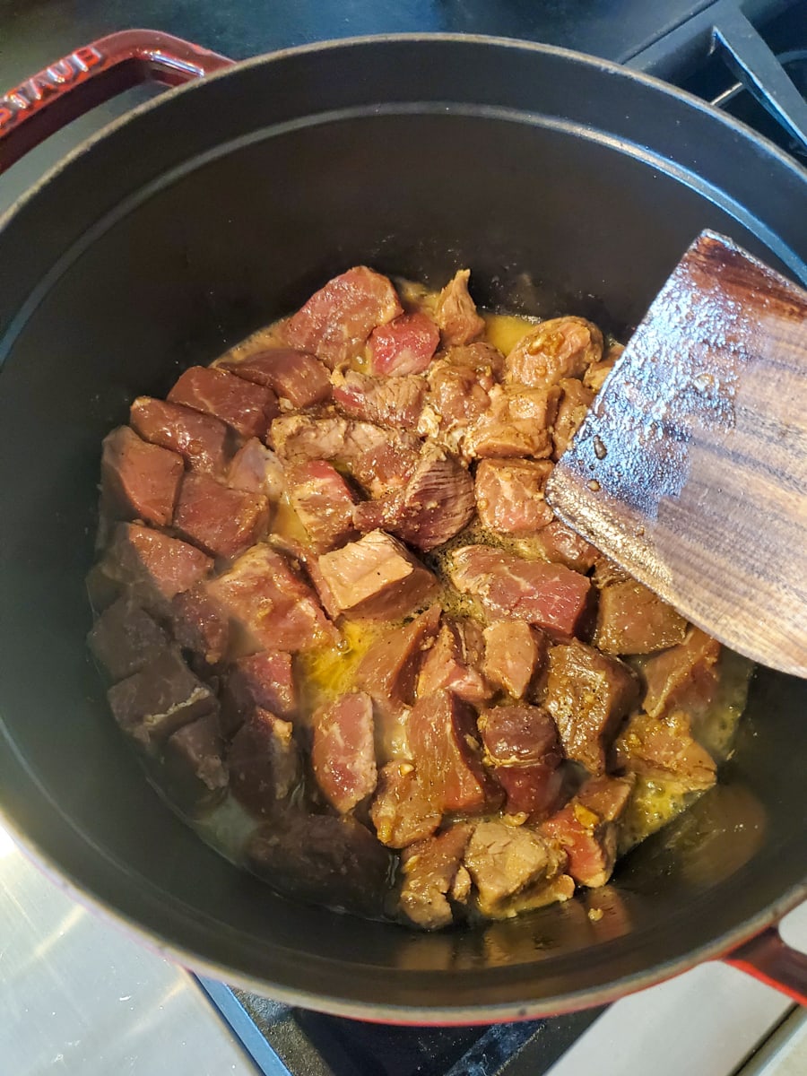 Stew beef browning in a Dutch oven.