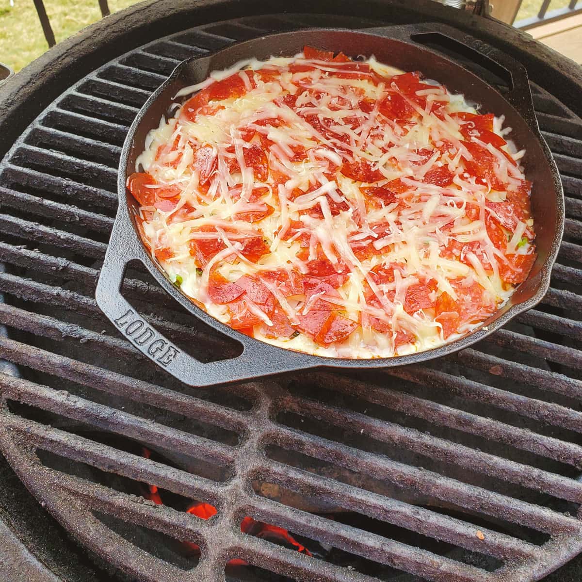 Cast iron pizza dip on a Big Green Egg.