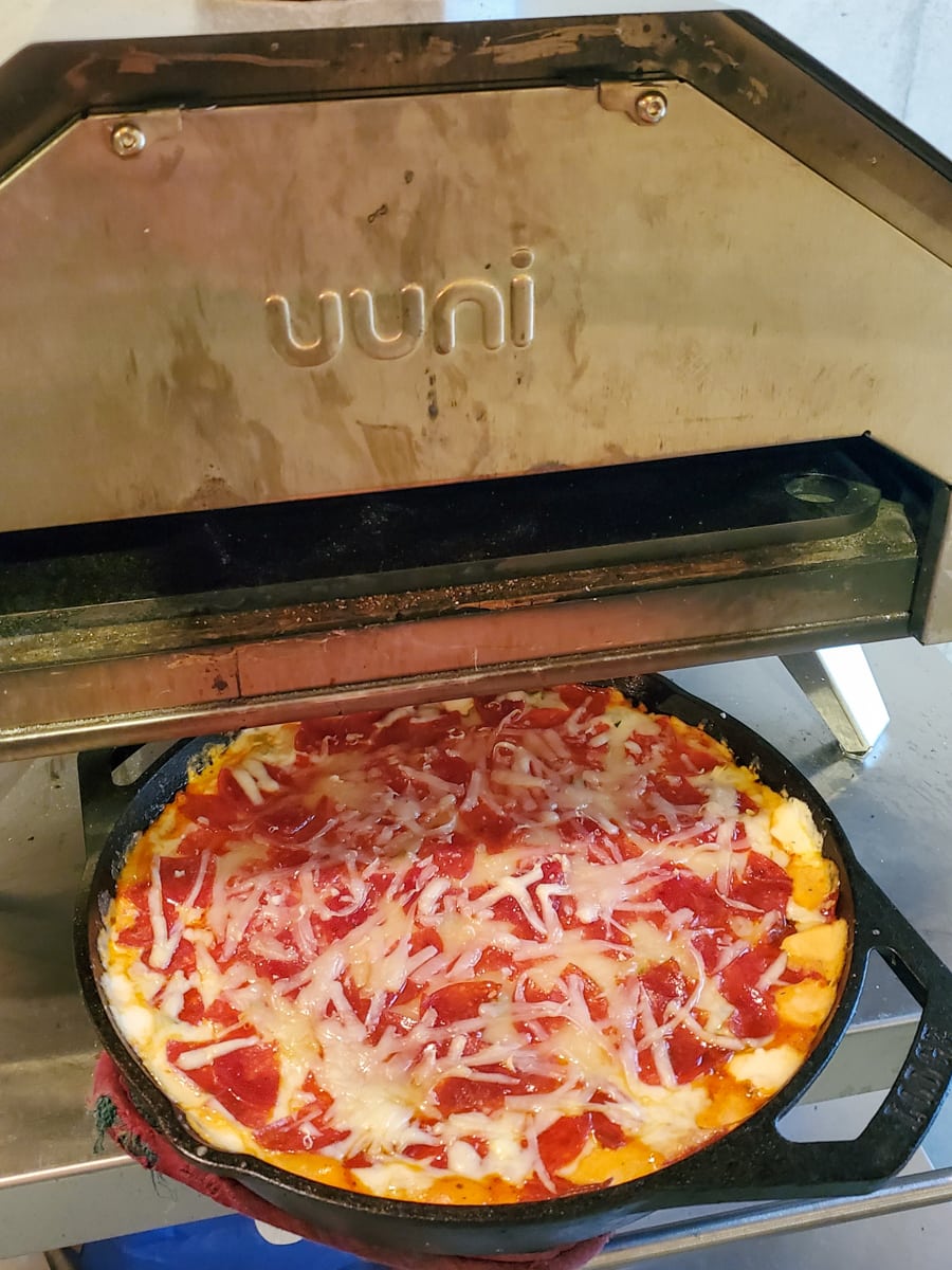 Cast iron pizza dip in a Ooni pizza oven.