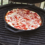 Wood fire pizza dip on a ceramic smoker.