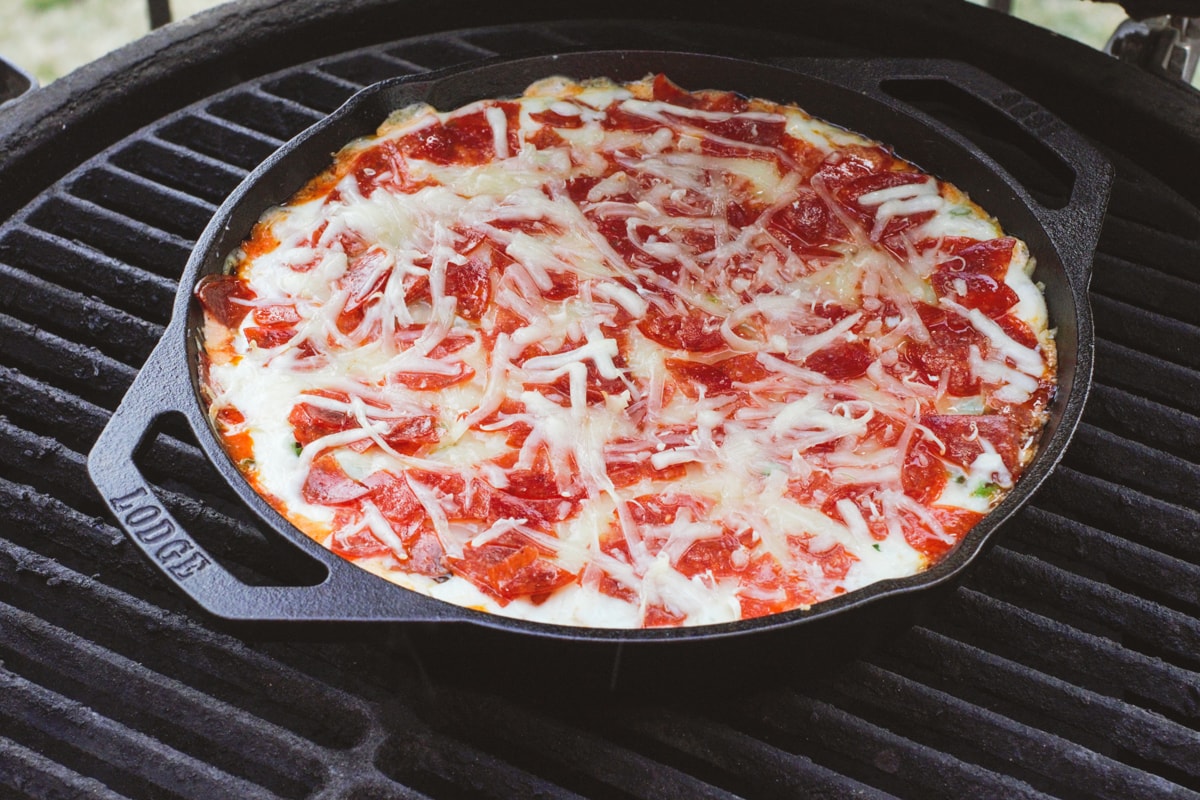 Pizza dip in a cast iron pan on a smoker.