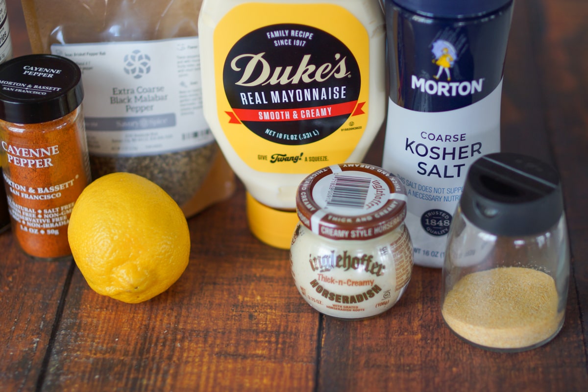 Lemon, Mayo, horseradish, salt, and garlic powder on a wood table.