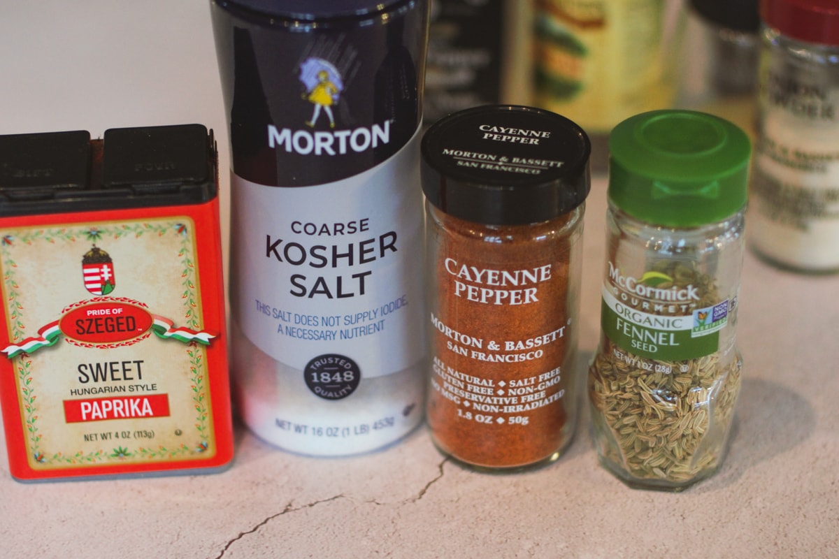Salt, paprika, cayenne, and fennel spice jars.
