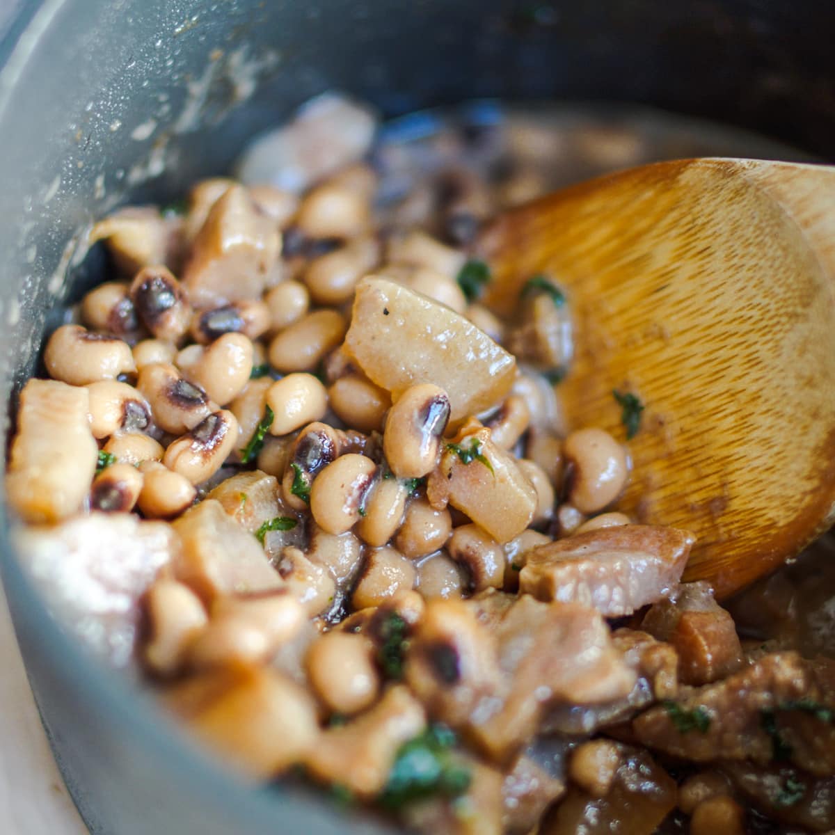 Pot of black-eyed peas with smoked hog jowl and kale.