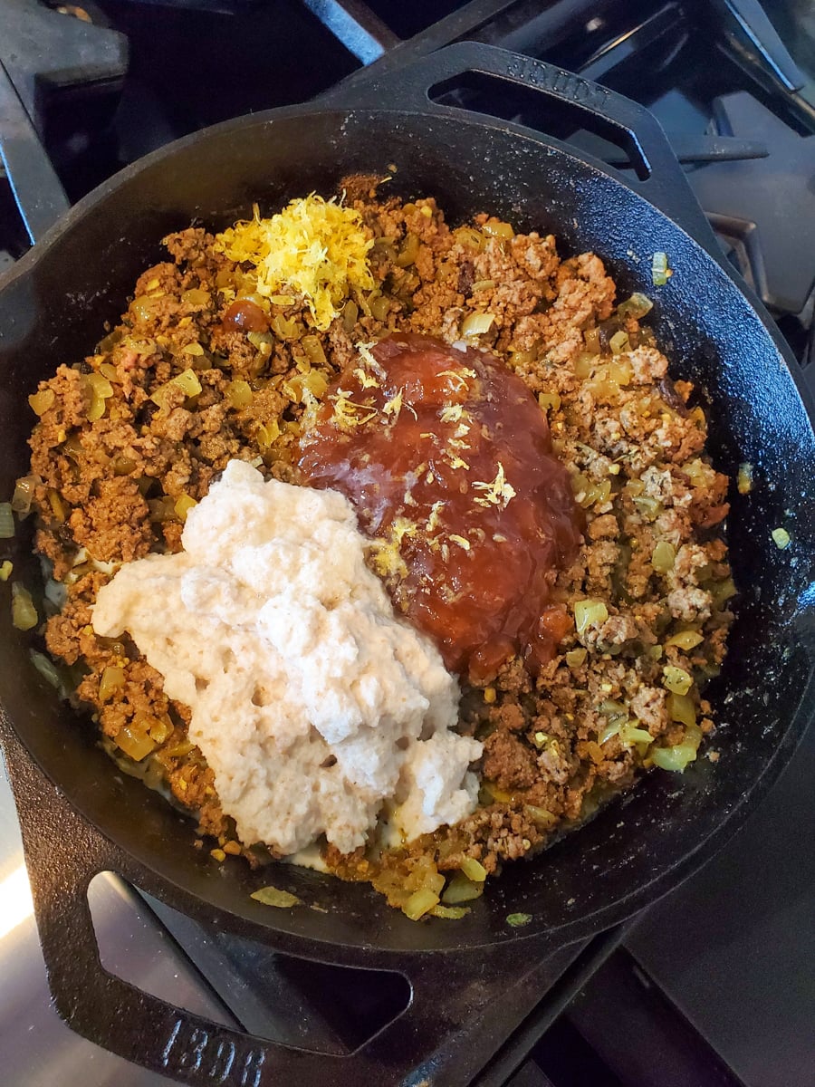 Milk soaked bread, Major Grey chutney, and lemon zest added to a skillet of ground beef for South African bobotie.