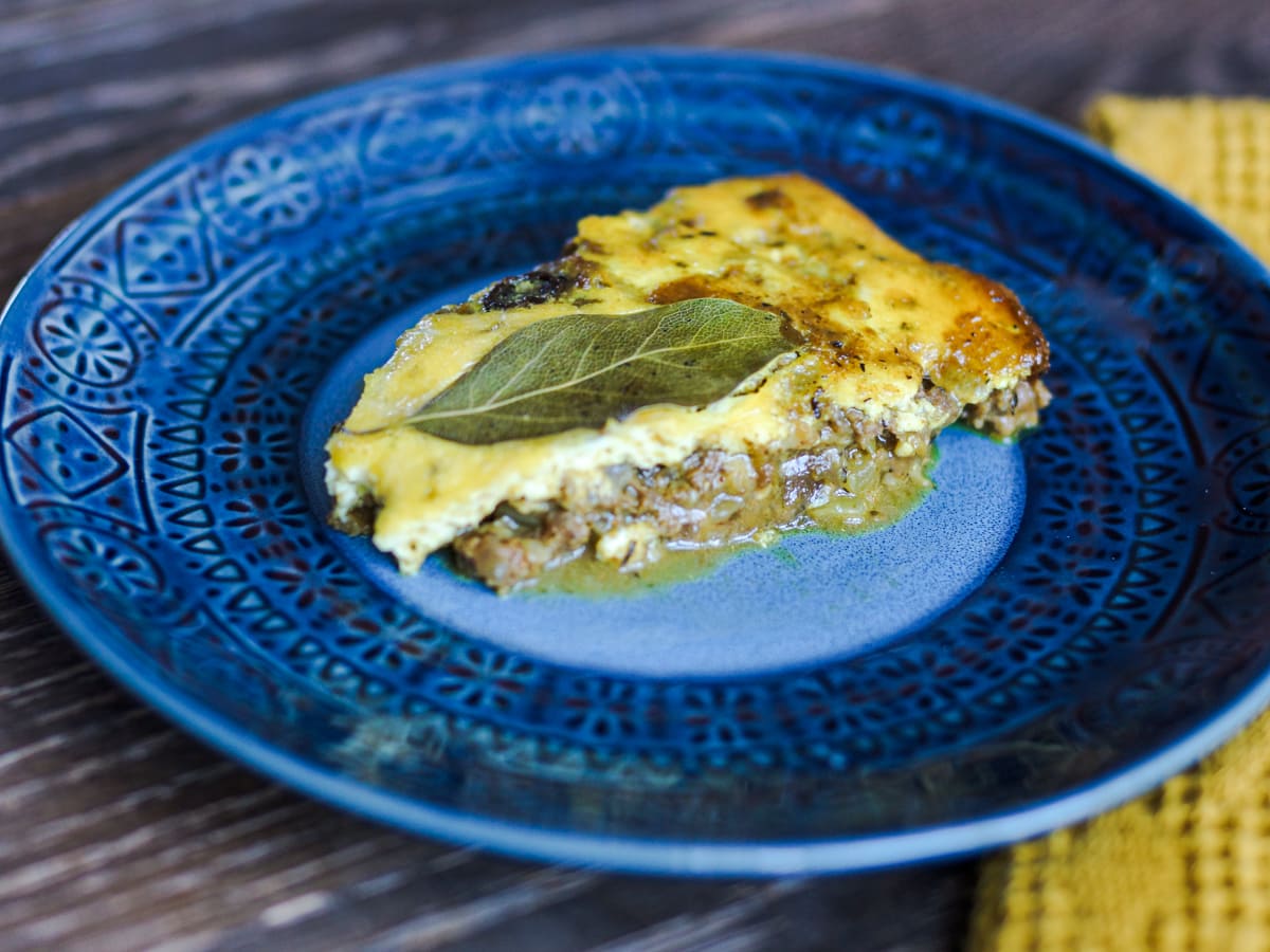 Slice of South African bobotie with curried ground beef, raisins, and egg custard.