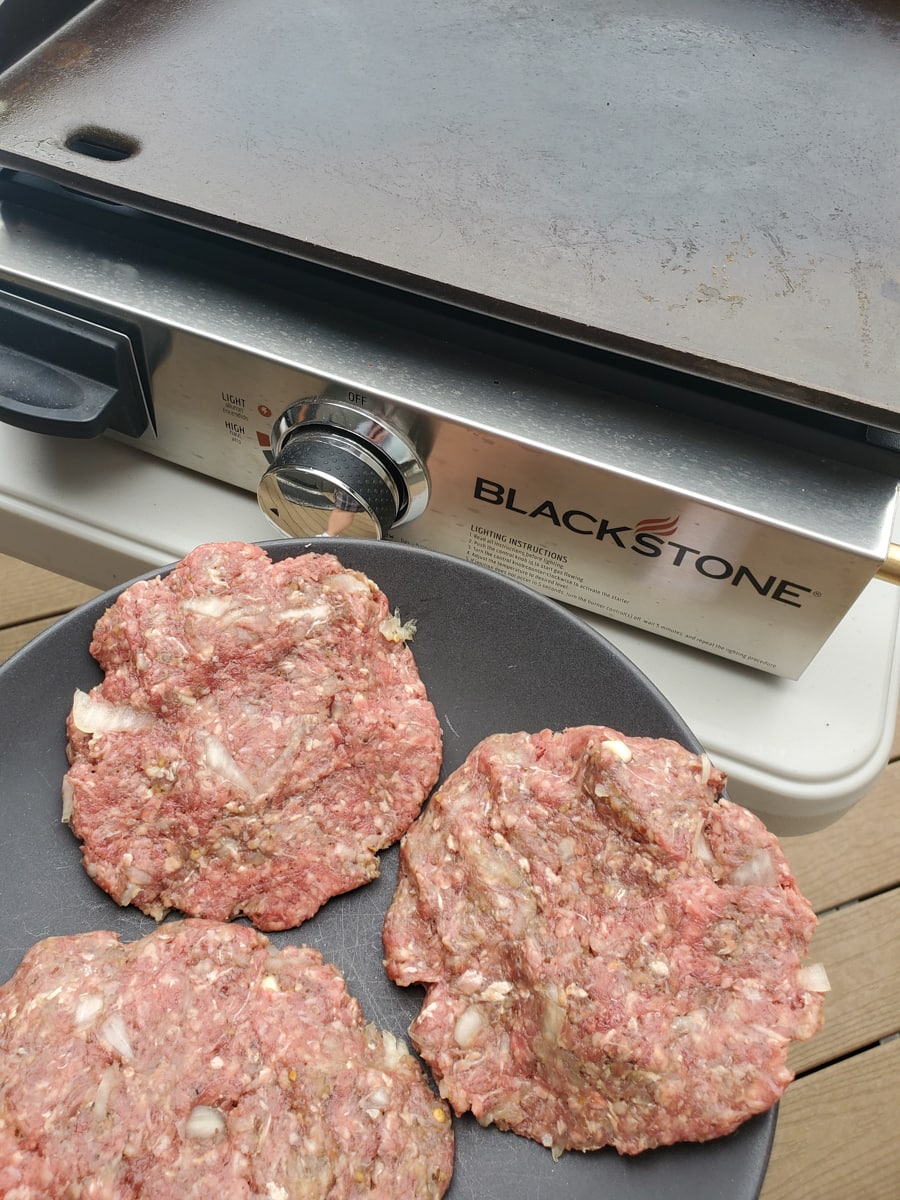 Burger patties ready to go on a Blackstone griddle.