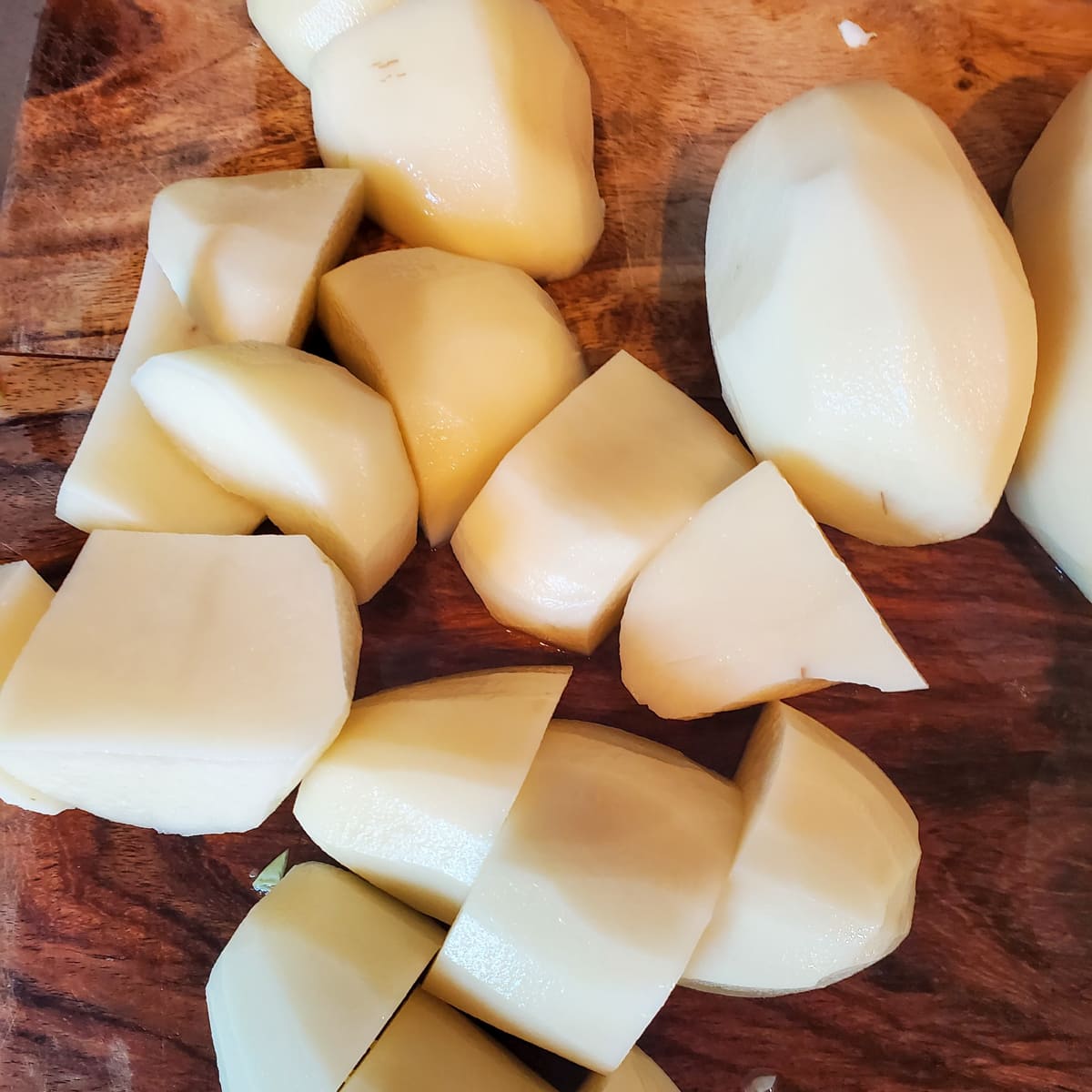 Peeled and cubed Russet potatoes on a cutting board.