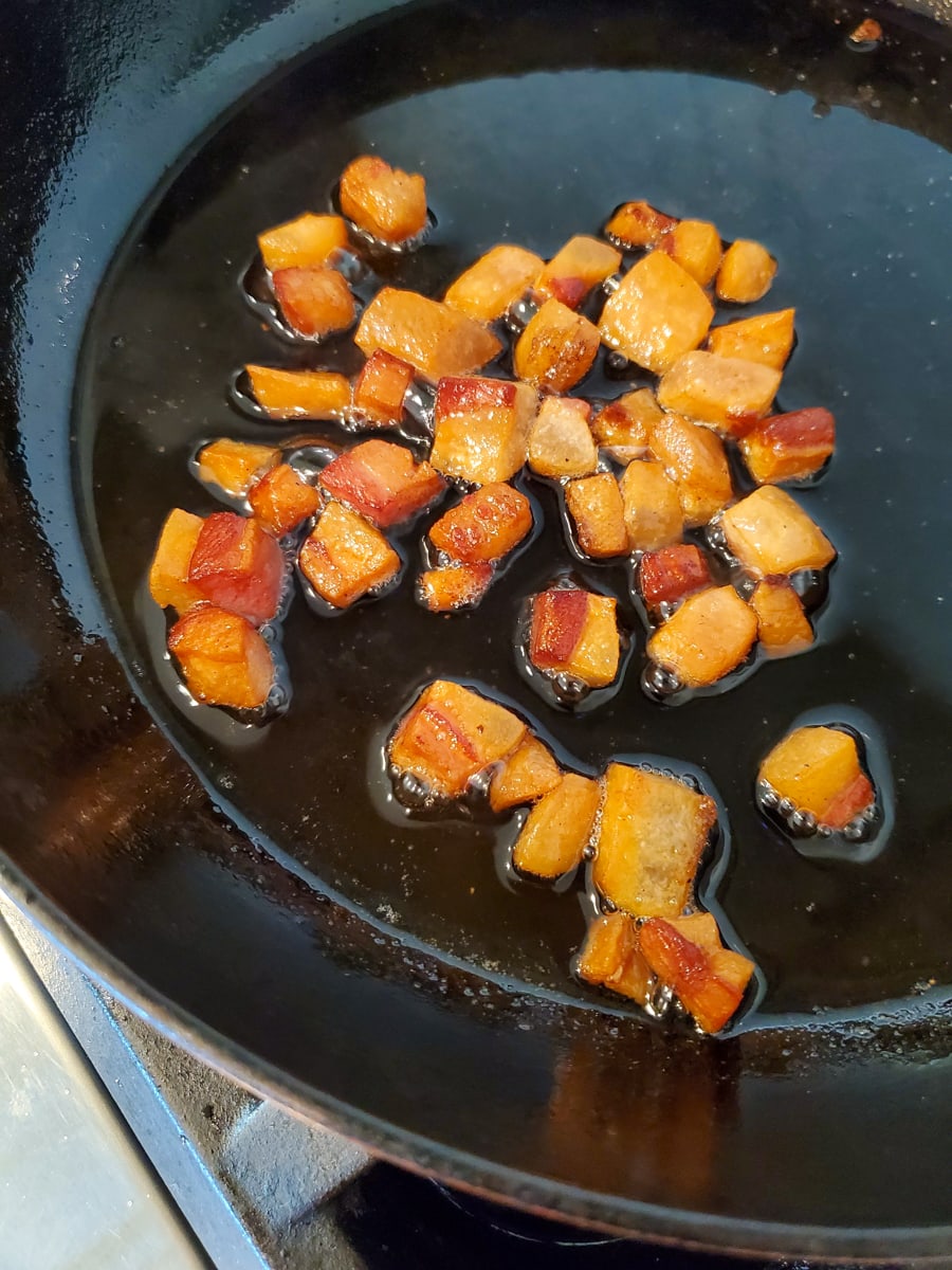 Italian guanciale frying in a pan.