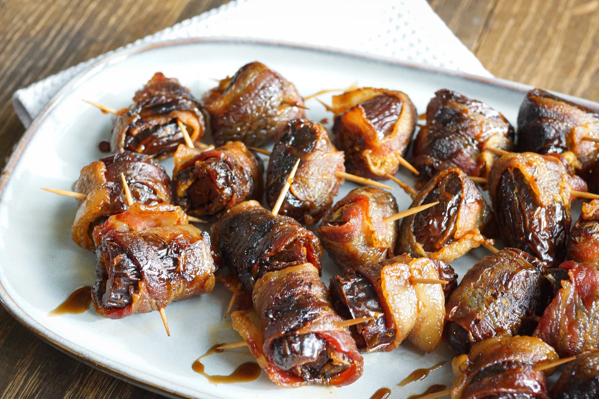 Devils on horseback appetizer: Grilled bacon wrapped dates stuffed with chorizo, drizzled with balsamic vinegar.