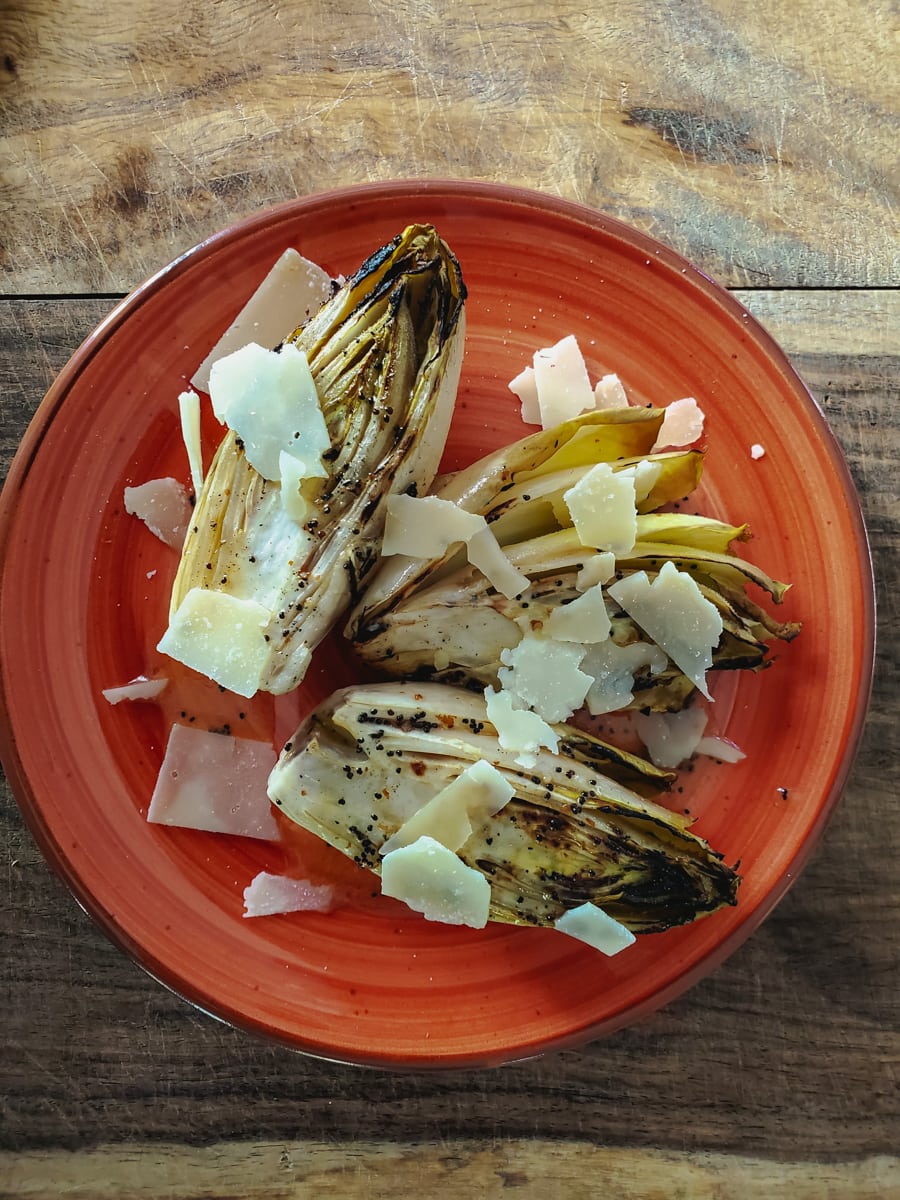 Grilled endive salad with poppy seed dressing and grated parmesan cheese.